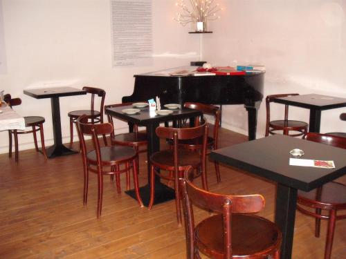 a group of tables and chairs with a piano at B&B Lo Straniero in Rivello