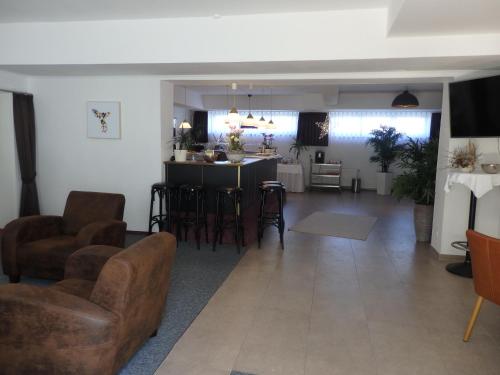 a living room with a couch and chairs and a table at Zur Saale in Weißenfels