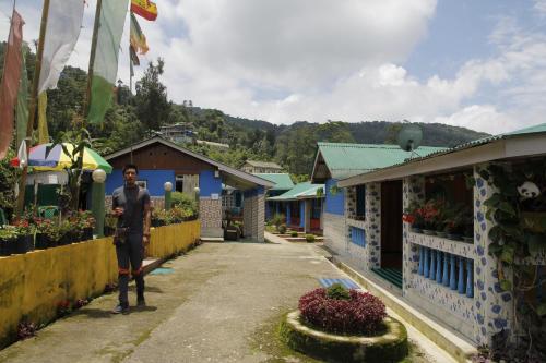 a man standing in a street in a village at Vamoose Orchid Villa Homestay in Rinchingpong