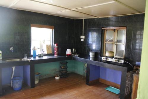 uma cozinha com um grande balcão longo num quarto em Vamoose Orchid Villa Homestay em Rinchingpong