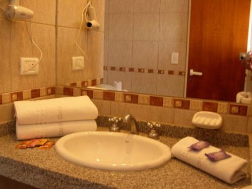 La salle de bains est pourvue d'un lavabo et d'un miroir. dans l'établissement Posada El Jarillal, à Sierra de la Ventana