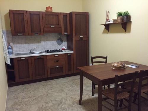 uma cozinha com armários de madeira e uma mesa com cadeiras em Agriturismo La Noce em Bassano Romano