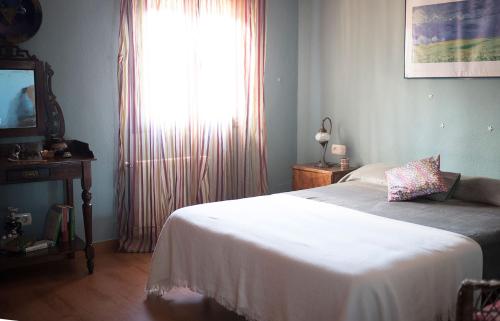 a bedroom with a bed and a large window at Mi Casita in Ronda