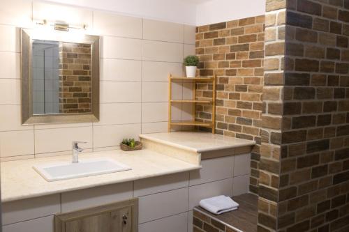 a bathroom with a sink and a brick wall at Blue4Aqua Apartments in Kavala