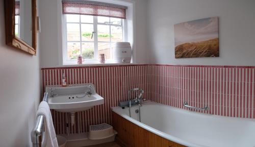ein Badezimmer mit Badewanne und Waschbecken in der Unterkunft Pear Tree Cottage in Aldeburgh