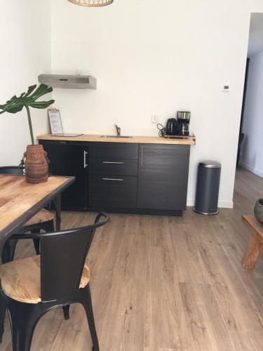 a kitchen with a wooden floor and wooden cabinets at appartementen zeespiegel in Zandvoort
