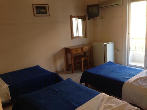 um quarto com 2 camas e um frigorífico em Avra Inn em Mesolongion