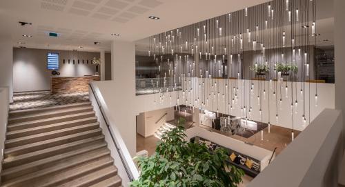 a lobby with a staircase and chandelier at Van der Valk Hotel Heerlen in Heerlen