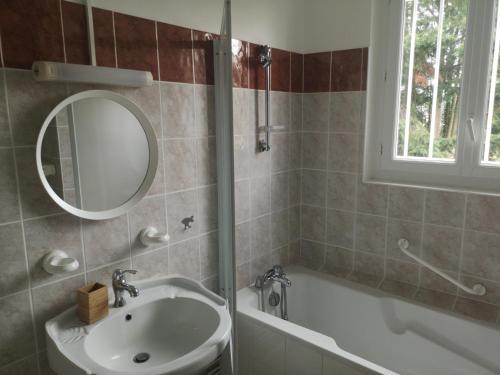 a bathroom with a sink and a tub and a mirror at La Nouvelle Criqueboise in Criquebeuf-en-Caux