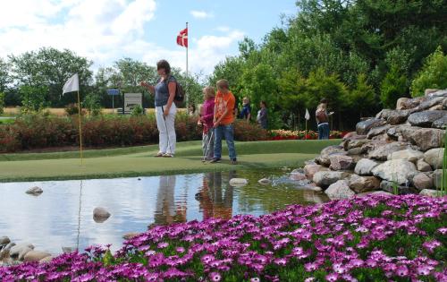 a group of people standing around a pond with flowers at Adventure Park Apartments in Ringkøbing