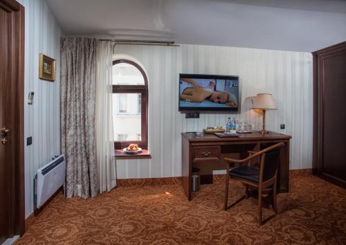 a hotel room with a desk and a window at Hotel Otrada in Odesa
