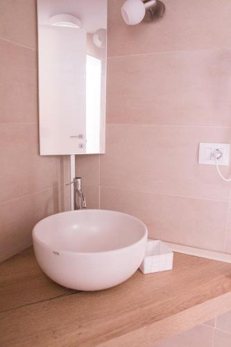 a bathroom with a white sink and a mirror at B&B SILVIA in Vecchiano