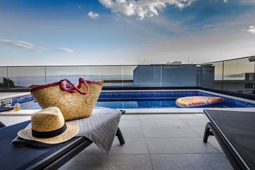 a hat sitting on a bench next to a swimming pool at New Mountainside Villa w Pool + Stunning Sea View in Makarska