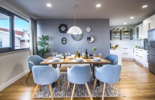 a dining room with a wooden table and blue chairs at New Mountainside Villa w Pool + Stunning Sea View in Makarska
