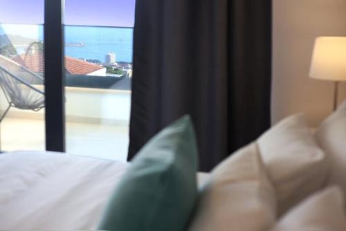 a room with a bed and a window with a view at New Mountainside Villa w Pool + Stunning Sea View in Makarska