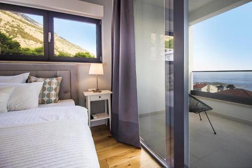 a bedroom with a bed and a large window at New Mountainside Villa w Pool + Stunning Sea View in Makarska