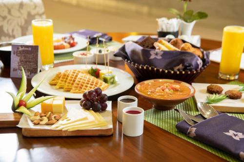 a table topped with plates of food and orange juice at Radisson Blu Resort Jizan in Jazan