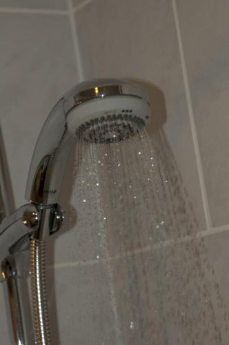 a shower with water coming out of the nozzle at The Queensgate Hotel in Peterborough
