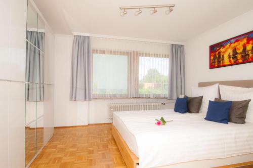 ウールディンゲン・ミュールホーフェンにあるBodenseeDomizilのベッドルーム(青い枕の大きな白いベッド付)