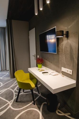 a room with a desk and a yellow chair at Hotel Sachsenross in Nörten-Hardenberg