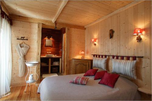 a bedroom with a bed in a wooden room at Hotel Le Rocher Blanc in Albaret-Sainte-Marie