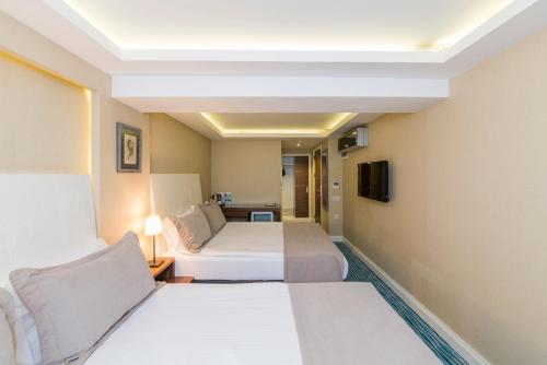 Un pat sau paturi într-o cameră la Aston Hotel Taksim