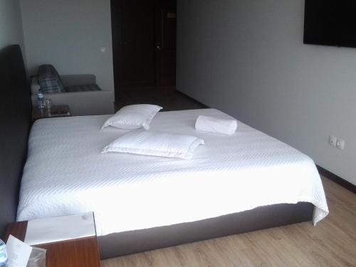 a bedroom with a white bed with white sheets and pillows at Guest House A&z in Espinho