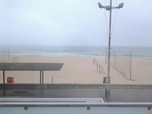a beach with a view of the ocean and a street light at Guest House A&z in Espinho