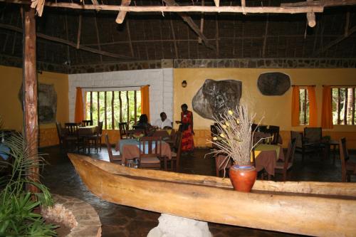 a large wooden boat in a room with a restaurant at Boko Boko Guesthouse and Hotel in Kikambala