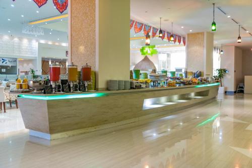 a restaurant with a counter with food on it at Radisson Blu Resort Jizan in Jazan