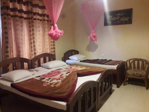 two twin beds in a room with two chairs at Highcliffe Guest House in Haputale