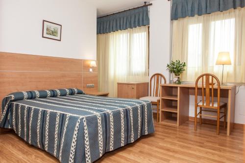 a bedroom with a bed and a table and chairs at Hotel Las Anclas in El Astillero