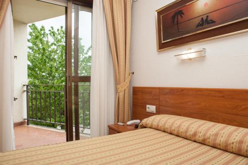 a hotel room with a bed and a balcony at Hotel Las Anclas in El Astillero