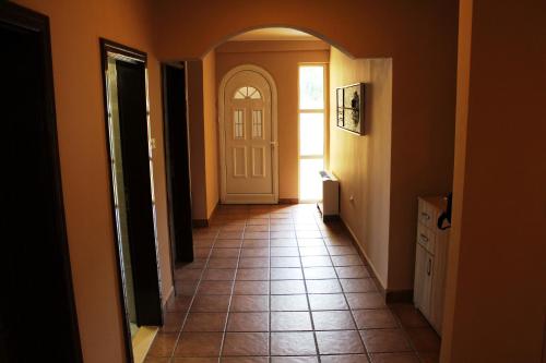 a hallway with a white door and a tile floor at Hotel Crnogorska Kuća in Podgorica