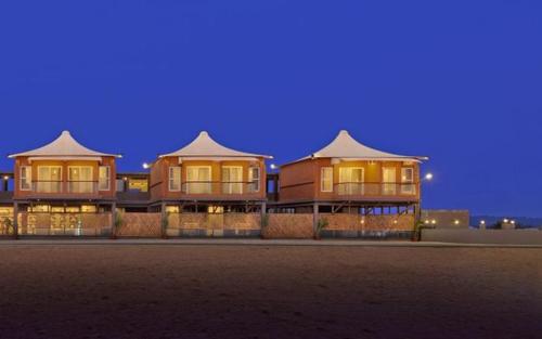 a large house at night with lights on at The Fern Leo Beach Resort , Madhavpur in Porbandar