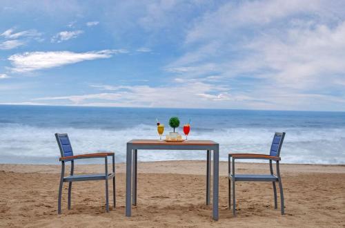 a table and two chairs on the beach at The Fern Leo Beach Resort , Madhavpur in Porbandar