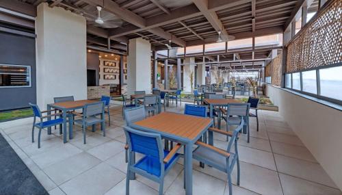 a dining room with tables and chairs in a restaurant at The Fern Leo Beach Resort , Madhavpur in Porbandar