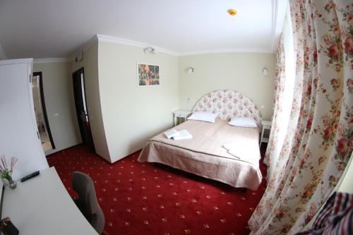 a small bedroom with a bed and red carpet at Casa Bucovineana in Suceava