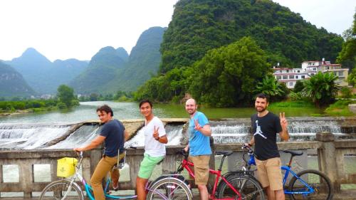 a group of men on bikes in front of a waterfall at Leisure Courtyard Hotel Yangshuo in Yangshuo