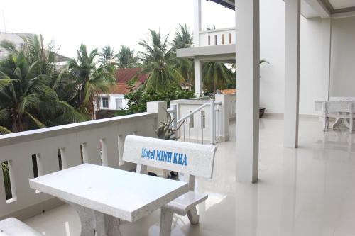 a white bench on a balcony with a sign on it at Minh Kha Hotel in Mui Ne