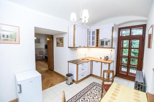 an open kitchen with white cabinets and a table at Penzion Šatlava in Nové Město nad Metují