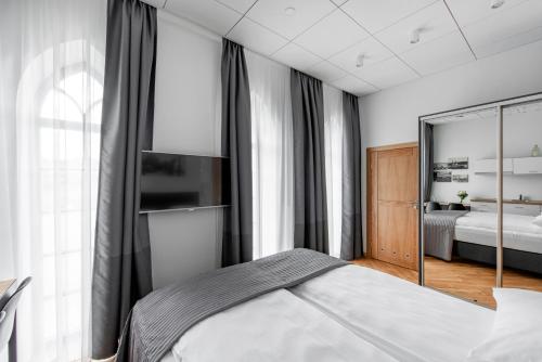 a bedroom with a bed and a mirror at Piano Apartments in Kaunas