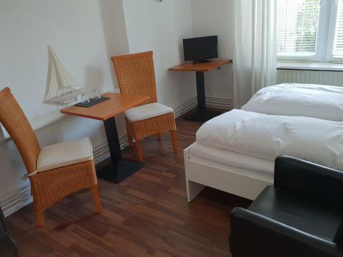 1 dormitorio con 1 cama, 2 sillas y escritorio en Budget en Westerland