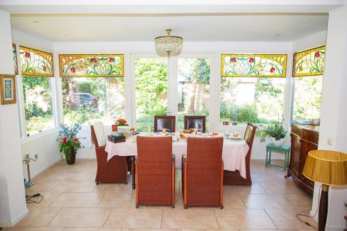 een eetkamer met een tafel met stoelen en glas-in-loodramen bij Bed and Breakfast Hoorn in Hoorn