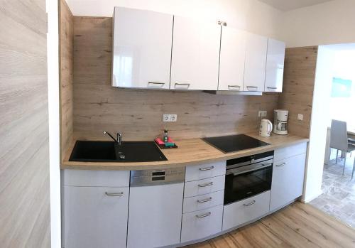 a kitchen with white cabinets and a sink at "Villa Seute Deern" Trassenheide, Familie Meutzner in Trassenheide