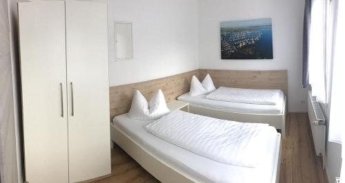 a room with two beds and a cabinet at "Villa Seute Deern" Trassenheide, Familie Meutzner in Trassenheide