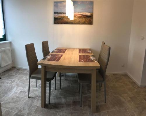 a dining room table with chairs and a picture on the wall at "Villa Seute Deern" Trassenheide, Familie Meutzner in Trassenheide