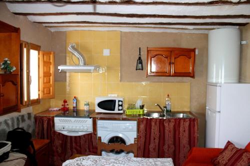a kitchen with a sink and a washing machine at Casa Rural con Jacuzzi Paraíso del Júcar in Alcalá del Júcar