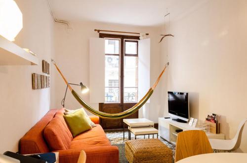 バルセロナにあるGreat apartment in Poblesecのリビングルーム(オレンジカウチ、ハンモック付)