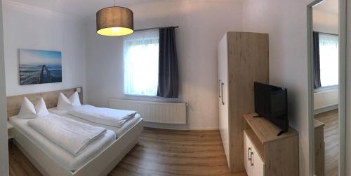a bedroom with a bed and a television in it at "Villa Seute Deern" Trassenheide, Familie Meutzner in Trassenheide